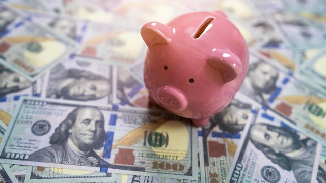 Pink Piggy Bank on Spread of Dollar Bills 