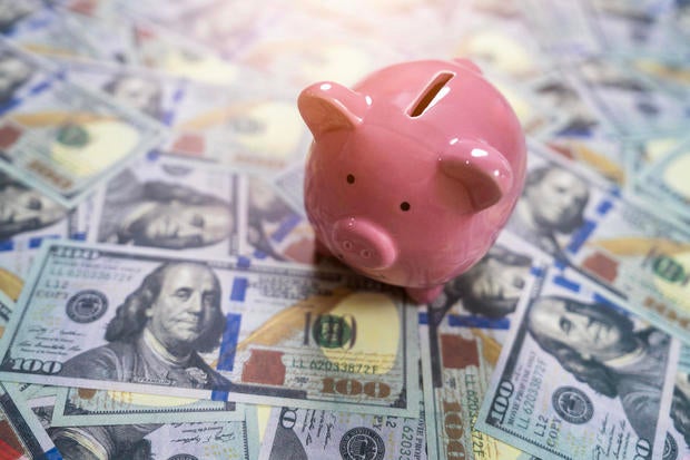 Pink piggy bank on spread dollar bills 