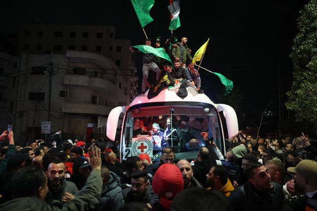 Palestinians celebrate the release of some 90 prisoners set free by Israel in the early hours of Jan. 20, 2025 upon their arrival aboard a Red Cross bus in the occupied West Bank town of Beitunia, on the outskirts of Ramallah