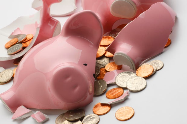 Coins strewn around broken pink piggy bank