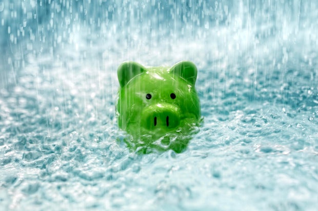 Piggy bank drowning in debt sinking in heavy rain water