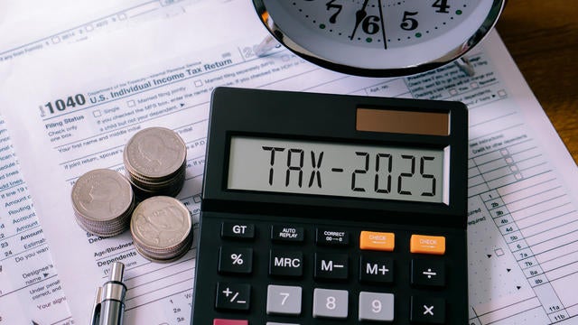 Word Tax 2025 on the calculator on documents.Income Statement. paying the tax rate. Taxation, taxes burden, savings and New Year Resolution.Business and tax concept. 