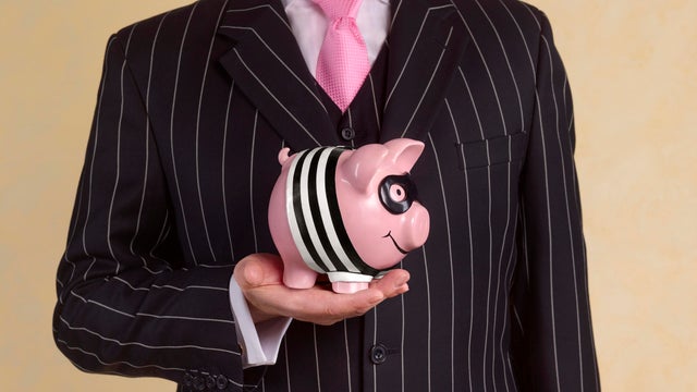 Banker/financial advisor with burglar piggy bank 