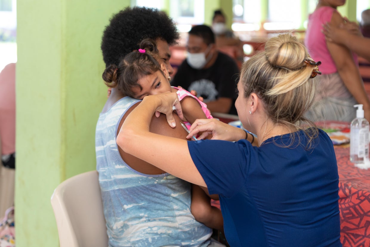 A nurse giving a vaccination shot to a child in Samoa