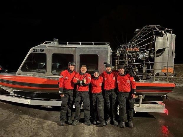 Coast Guard crew of five near their ice boat. 