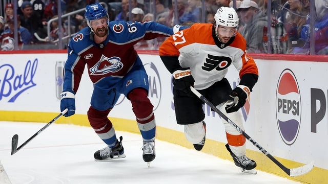 Noah Cates of the Philadelphia Flyers brings the puck off the boards against Keaton Middleton of the Colorado Avalanche 