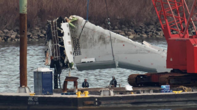 A crane retrieves a wing from the wreckage of American Eagle Flight 5342 in the Potomac River following the deadly midair collision with a Black Hawk helicopter, by Ronald Reagan Washington National Airport, in Arlington, Virginia, Feb. 3, 2025. 