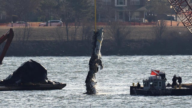 A crane retrieves part of the wreckage from the Potomac River, in the aftermath of the collision of American Eagle Flight 5342 and a Black Hawk helicopter, by Ronald Reagan Washington National Airport, in Arlington, Virginia, Feb. 4, 2025. 