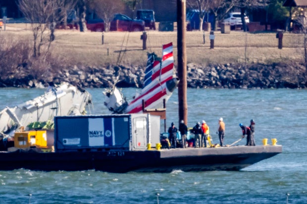 Parts of a plane are lifted from the Potomac River near the wreckage site of the midair collision between an American Airlines jet and a Black Hawk helicopter, at Ronald Reagan Washington National Airport, Feb. 4, 2025, in Arlington, Virginia.