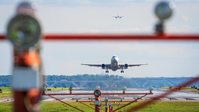 A passenger jet is framed in the runway threshold lights on takeoff as another jet lines up for landing in the background at Ronald Reagan Washington National Airport on Aug. 12, 2024, in Arlington, Virginia. 