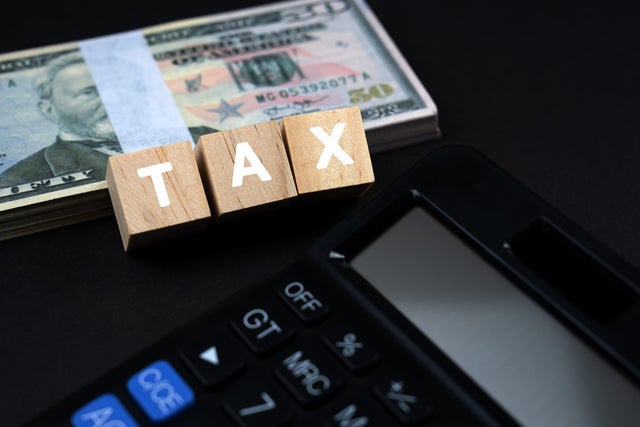 Tax Text on Wood Block With 50 American Dollar and Calculator 