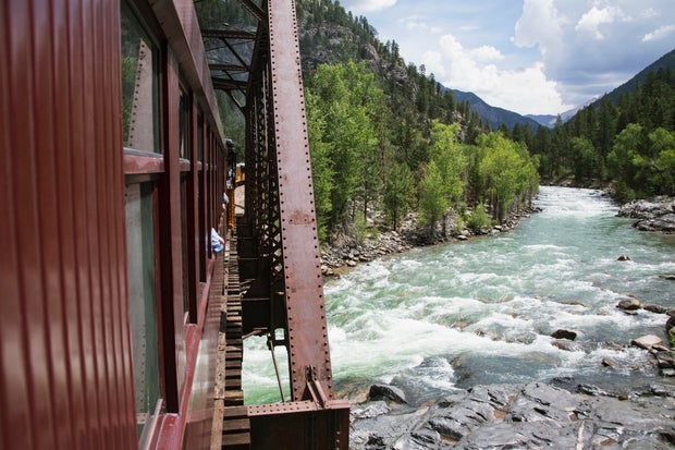 The Durango and Silverton Narrow Gauge Railroad Steam Engine travels along Animas River, Colorado, U 