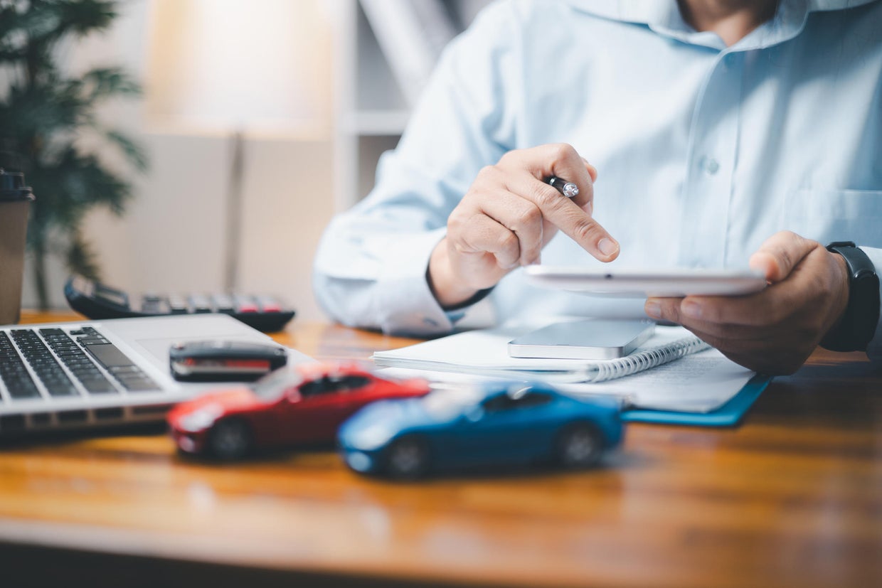 Toy Car In Front Of Businessman Calculating Loan. Saving money for car concept, trade car for cash concept, finance concept. 