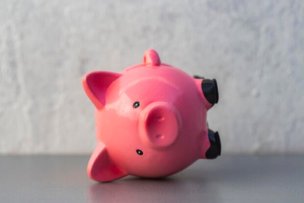 close up view of pink piggy bank upside down - finance crisis concept 