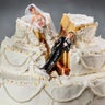 Bride and groom figurines collapsed at ruined wedding cake 