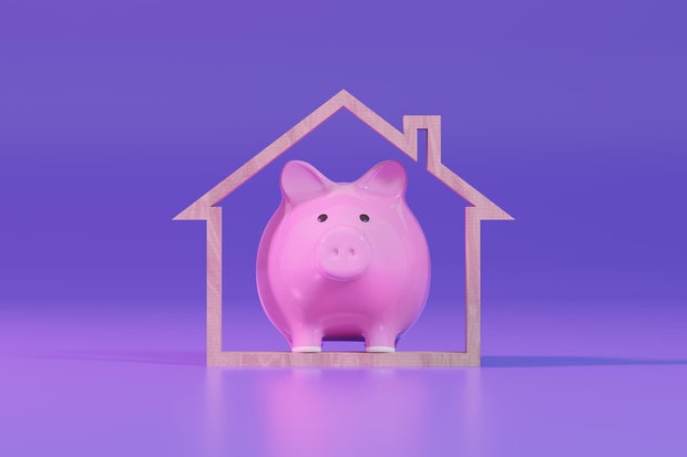 Piggy Bank and Wooden House Shape. Mortgage Loan and Home Ownership.