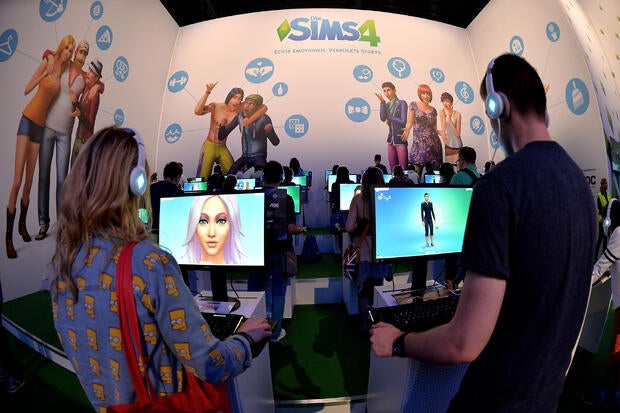 Visitors try out the game The Sims 4 at the Electronic Arts stand at the Gamescom gaming trade fair on Aug. 14, 2014, in Cologne, Germany.