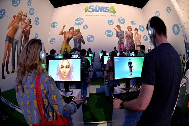 Visitors try out the game The Sims 4 at the Electronic Arts stand at the Gamescom gaming trade fair on Aug. 14, 2014, in Cologne, Germany.