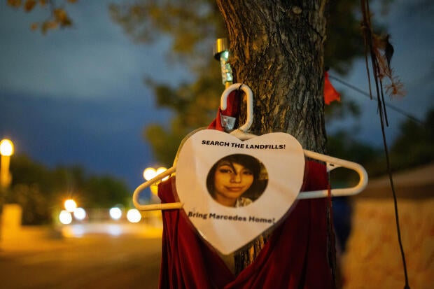 On a tree out front of Camp Marcedes, located next to the Canadian Museum for Human Rights, a photo and red dress signify the loss of Marcedes Myran with a call to action in searching the landfills for her remains from Downtown Winnipeg