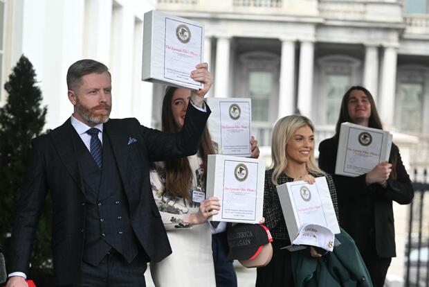 From left, Rogan O'Handley, Chaya Raichik, Scott Presler, Liz Wheeler and Chad Prather carry binders labeled "The Epstein Files: Phase 1" as they walk out of the West Wing of the White House on Thursday, Feb. 27, 2025. 