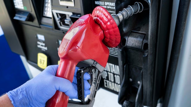 Gloved hand holding gas station nozzle 