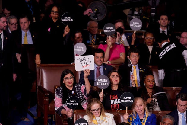 House Democrats hold signs in protest during a joint session of Congress on Tuesday, March 4, 2025. 