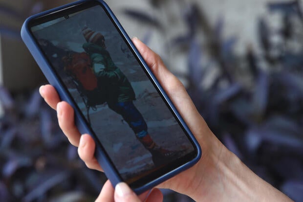 Azul Vieiro, 44, daughter of the late legendary mountaineer Guillermo Vieiro, looks at a picture of his father in her mobile phone during an interview in Mendoza, Argentina