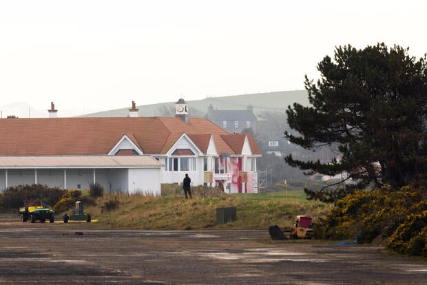 A man looks towards club house covered in red paint in the aftermath of a pro-Palestinian protest on U.S. President Trump's golf course in Turnberry 