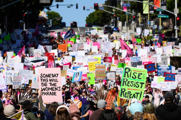 Demonstrators hold up signs during a march to commemorate International Women's Day Saturday, March 8, 2025, in Los Angeles