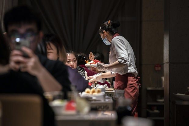 An employee serves a dish inside a Haidilao hotpot restaurant, operated by Haidilao International Holding Ltd., in Shanghai, China