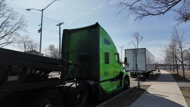 Two commercial vehicles parked on the side of a street in Queens. 