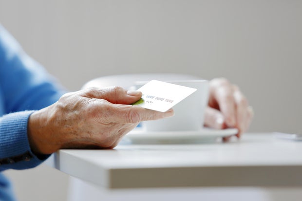 Mature hand holding a credit card 