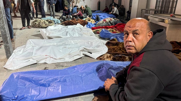 Mourners gather near the bodies of Palestinians killed in Israeli strikes, at a hospital in Gaza City