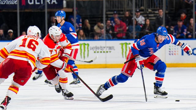 Will Cuylle #50 of the New York Rangers skates with the puck against Matt Coronato #27 of the Calgary Flames at Madison Square Garden on March 18, 2025 in New York City. 