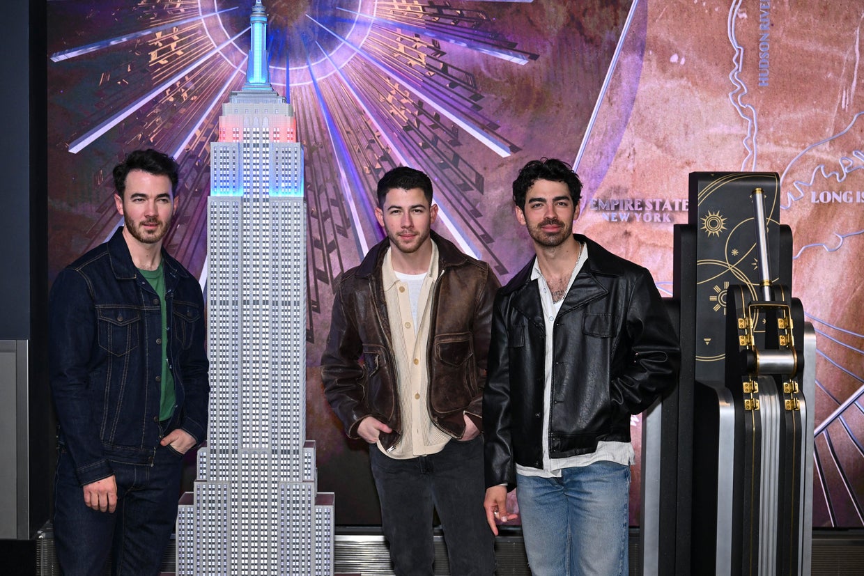 The Jonas brothers Kevin Jonas, Nick Jonas, and Joe Jonas, light the Empire State Building in blue and red during iHeartMedia New York's Z100 celebration of the 20th anniversary of their band in New York on March 21, 2025. 