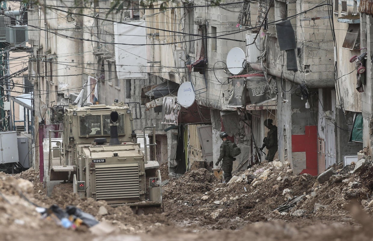 Israeli soldiers stand near a military bulldozer in the 