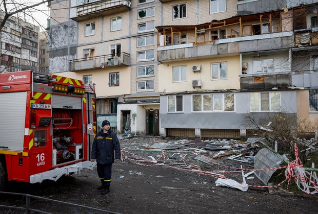 A firefighter works at the site of an apartment building that was hit by a Russian drone strike in Kyiv, Ukraine