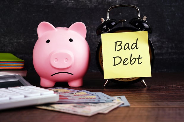 Piggy Bank and Adhesive Note With Text Bad Debt