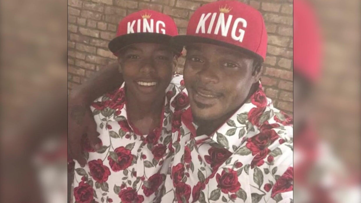 Sincere Jazmin and Miguel Jazmin in matching floral shirts and "KING" baseball hats 