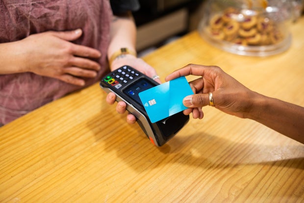 Woman's hand paying with a blue credit card 