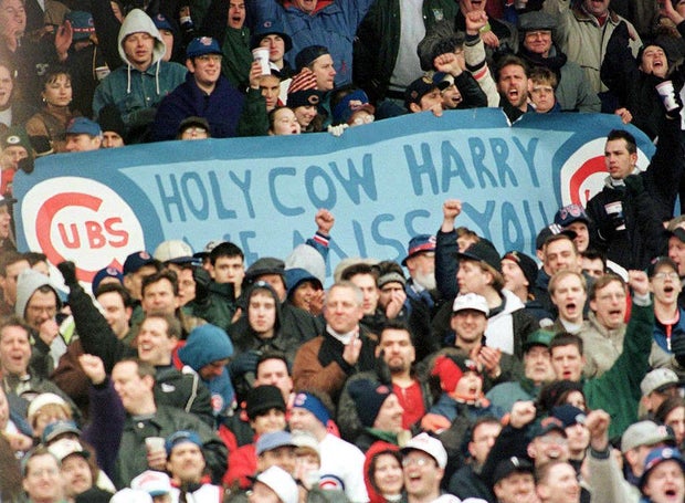 Chicago Cubs' fans hold a sign and cheer in memory