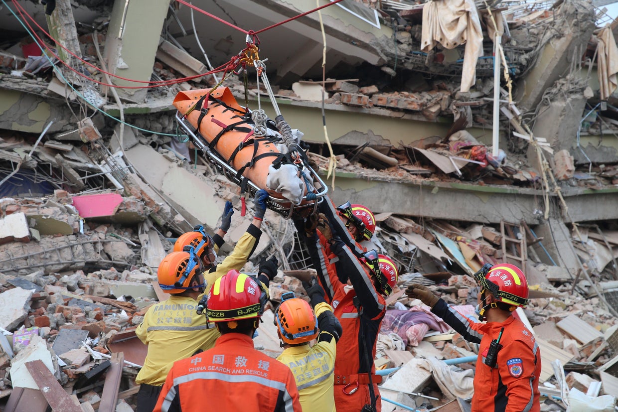 Members from the China Search and Rescue Team and the Rescue Team of Ramunion jointly transfer a pregnant survivor at a quake site in Mandalay city, Myanmar