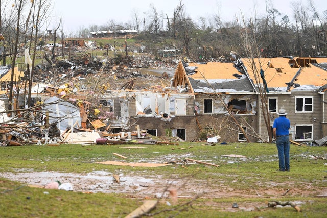 A man looks at debris on the ground after apartments were struck by a tornado in Selmer, Tennessee, April 3, 2025. 