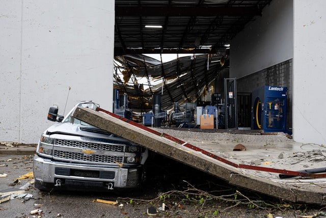 A damaged truck sits under a section of collapsed warehouse wall after violent storms and tornadoes tore through the area around Jeffersontown, Kentucky, April 3, 2025. 