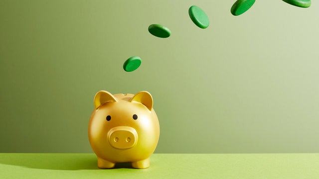 Coins flying into a piggy bank 