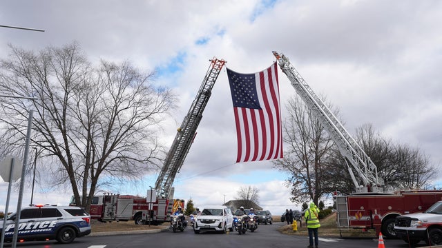 An American flag hangs between two fire trucks during the funeral for police officer Andrew Duarte in Red Lion, Pennsylvania 