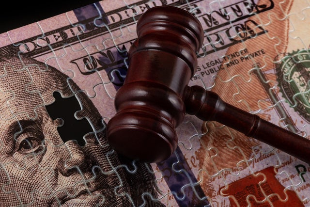 Puzzle in the form of a $100 bill and a judge's gavel 