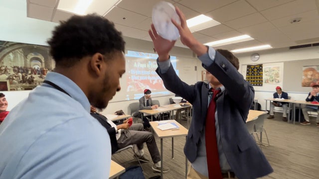 A student places a hat on the head of another student who has been selected as pope in the mock conclave at St. Joe's Prep School in Philadelphia 
