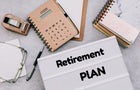 directy above workspace with laptop and office supplies.Retirement plan reminder 