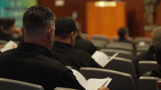 Participants sit in the auditorium during a private police training session 